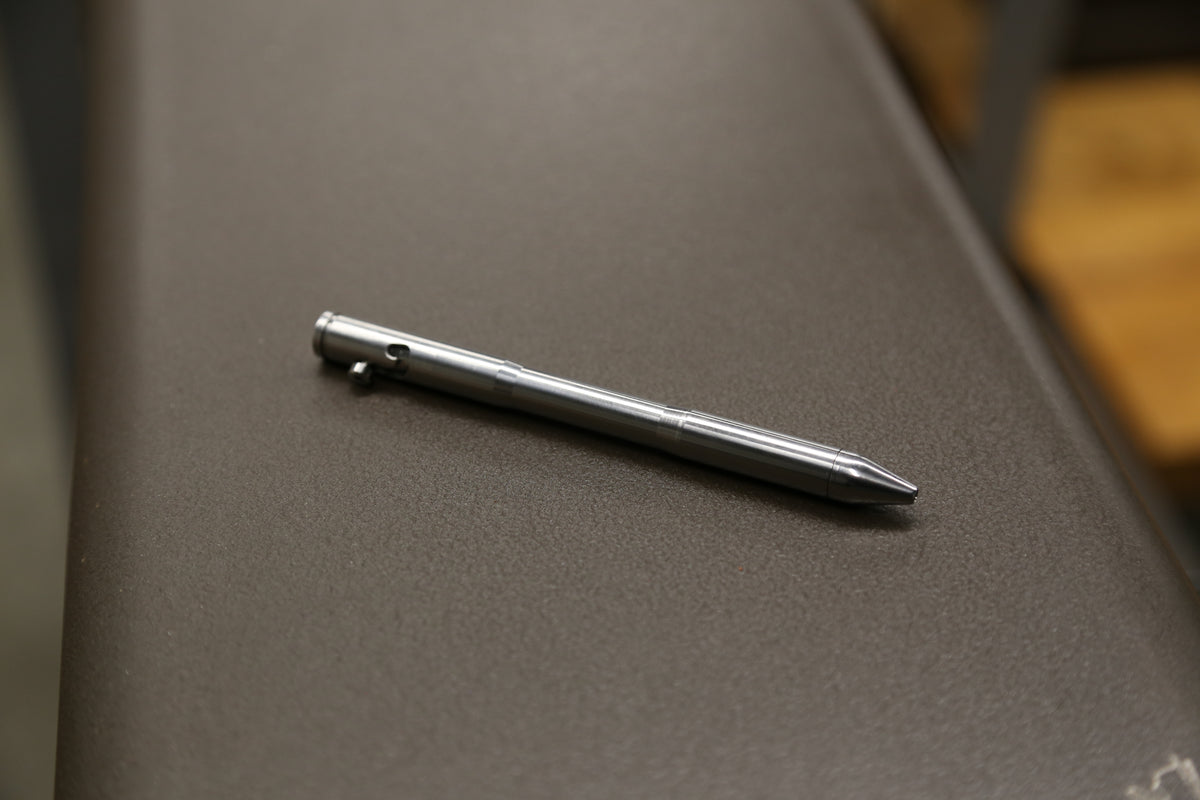 Drift titanium bolt-action pen resting on a workshop tray.