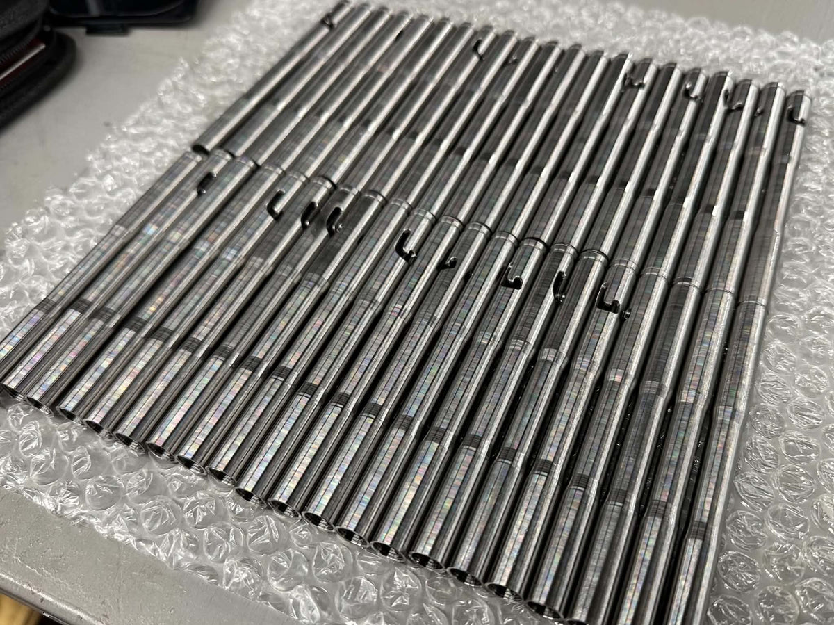 A batch of machined Drift pen bodies arranged on protective packaging in the workshop.