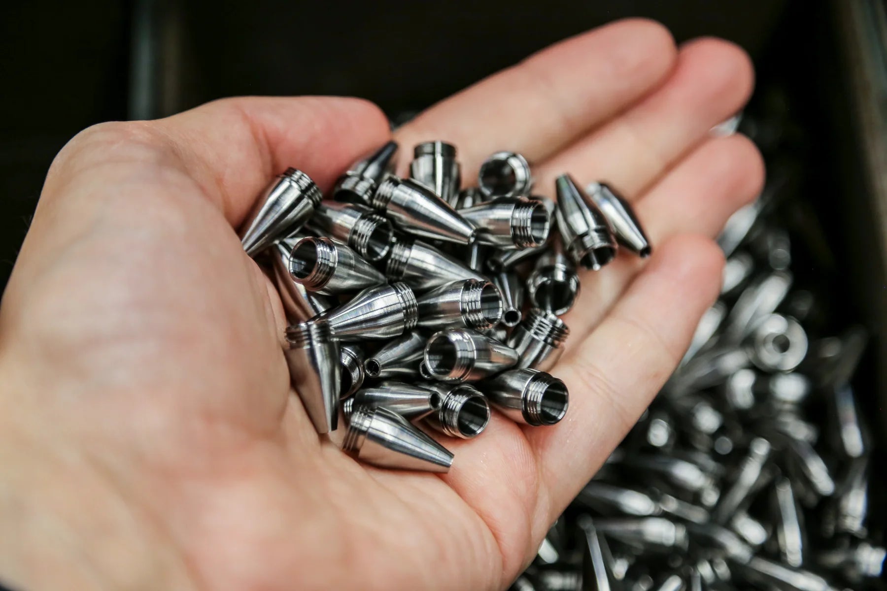 Finished precision-machined components held in hand